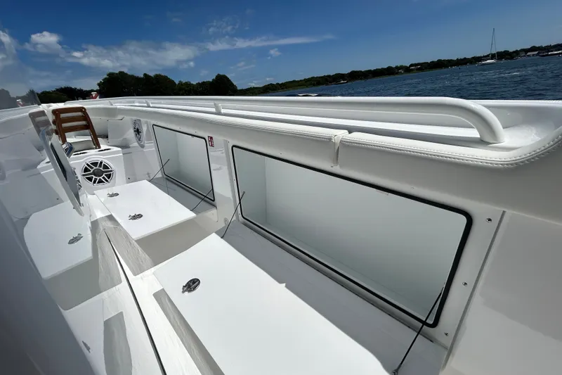 Slide: The Image of 2027 Everglades 315 Center Console boat interior with seating and storage, on a sunny day. - 34