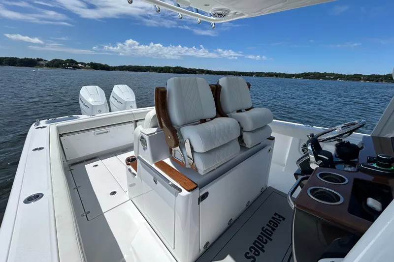 Slide: The Image of 2027 Everglades 315 Center Console boat interior with dual engines on a serene lake. - 40