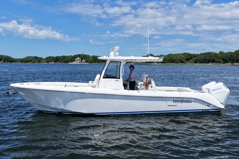 Slide: The Image of 2027 Everglades 315 Center Console boat on water, clear sky background. - 11