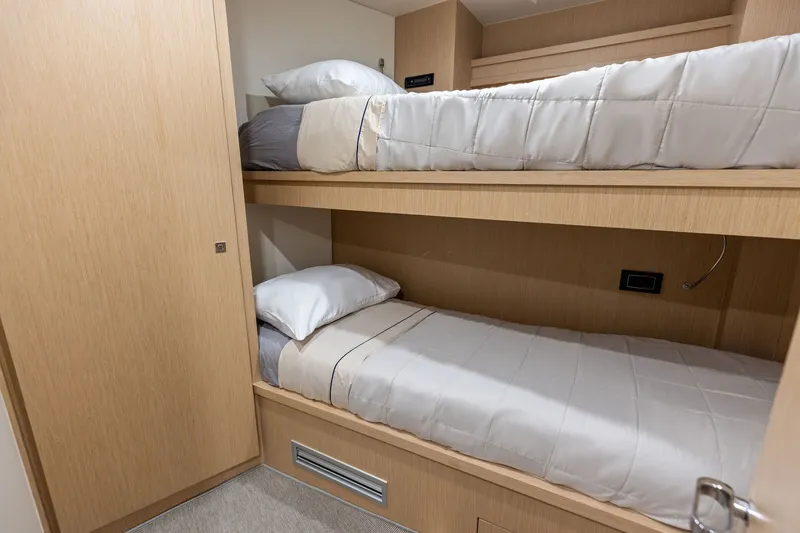Slide: The Image of Bunk beds in a 2022 Riva 110' Dolcevita yacht cabin, featuring light wood finishes. - 69