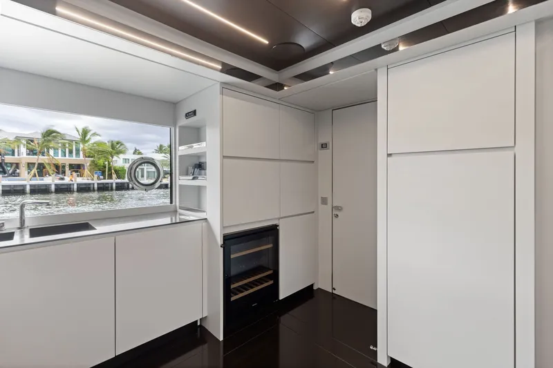 Slide: The Image of Modern kitchen interior on 2022 Riva 110' Dolcevita yacht, featuring sleek white cabinetry and waterfront view. - 38
