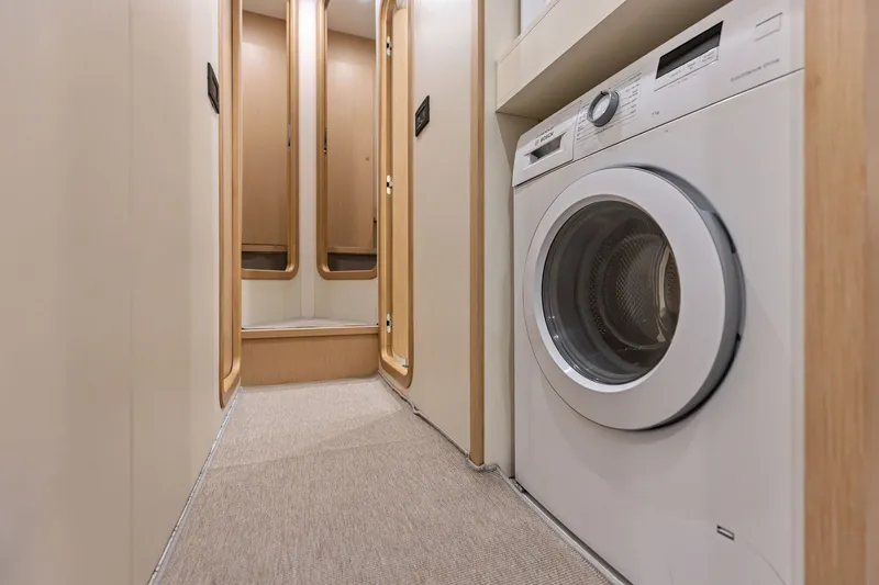 Slide: The Image of Laundry area inside 2022 Riva 110' Dolcevita yacht, featuring modern washing machine. - 71