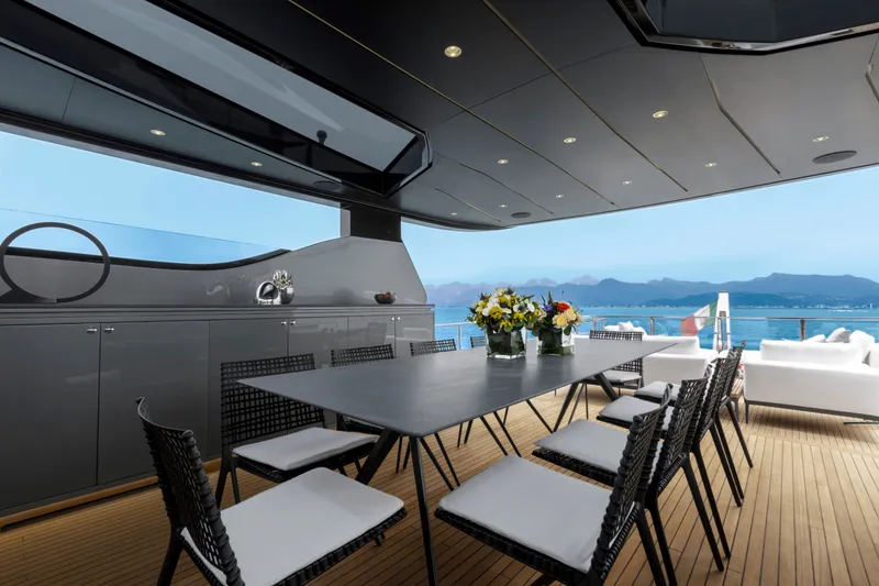 Slide: The Image of Luxurious 2024 Mangusta GranSport 33 yacht deck with elegant dining area and ocean view. - 55