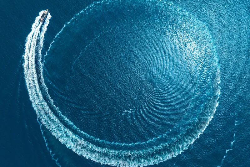 Slide: The Image of Aerial view of 2024 Mangusta GranSport 33 creating circular wake in blue ocean. - 65