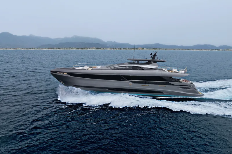 Slide: The Image of 2024 Mangusta GranSport 33 yacht cruising on open water with scenic mountain backdrop. - 1