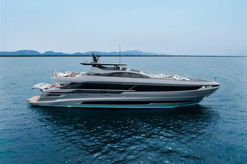 Slide: The Image of 2024 Mangusta GranSport 33 yacht cruising on open water, with scenic mountain backdrop. - 8