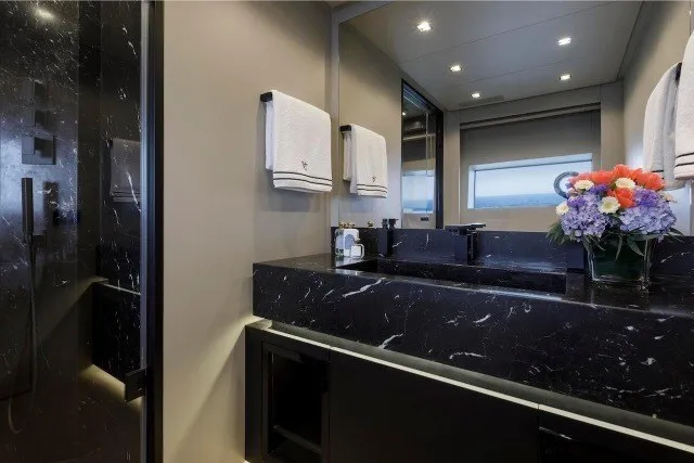 Slide: The Image of Luxurious bathroom in 2024 Mangusta GranSport 33 yacht with elegant black marble accents. - 27