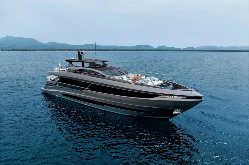 Slide: The Image of 2024 Mangusta GranSport 33 yacht cruising on open sea with mountainous backdrop. - 11