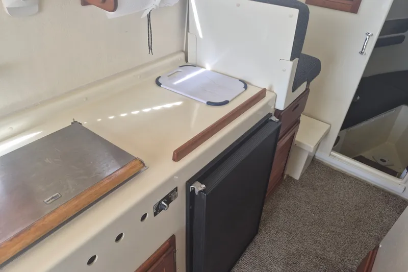 Slide: The Image of Interior of a 2006 Rosborough RF-246 boat featuring a compact kitchenette area. - 11
