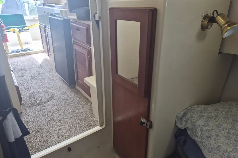 Slide: The Image of Interior of 2006 Rosborough RF-246 boat with carpet, wooden cabinets, and a small bed. - 12