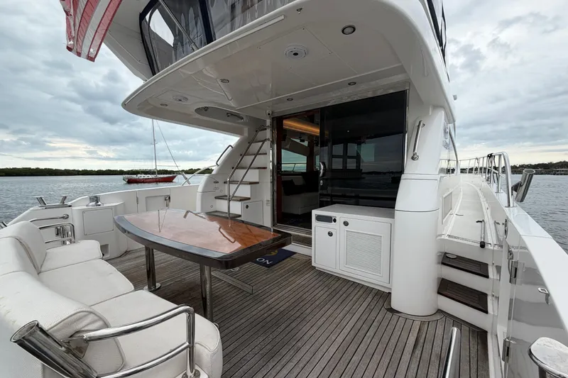 Slide: The Image of Luxurious 2020 Horizon E56 yacht deck with seating, table, and scenic water view. - 19
