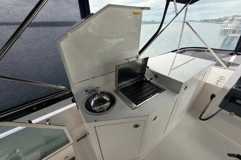 Slide: The Image of Outdoor kitchen on 2020 Horizon E56 yacht with grill and sink, overlooking marina. - 83
