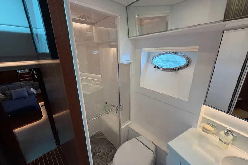 Slide: The Image of Luxurious bathroom interior on 2020 Horizon E56 yacht, featuring modern fixtures and ocean-view porthole. - 66