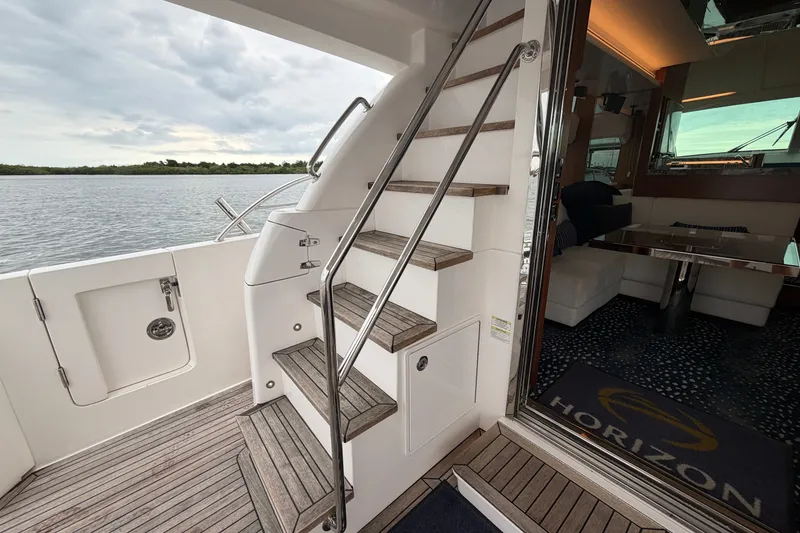 Slide: The Image of Staircase on Horizon E56 yacht, 2020 model, leading to luxurious interior with scenic water view. - 25