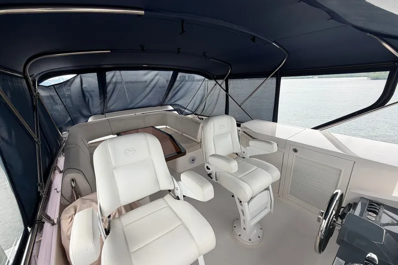 Slide: The Image of Luxurious 2020 Horizon E56 yacht interior with white captain chairs and panoramic windows. - 79