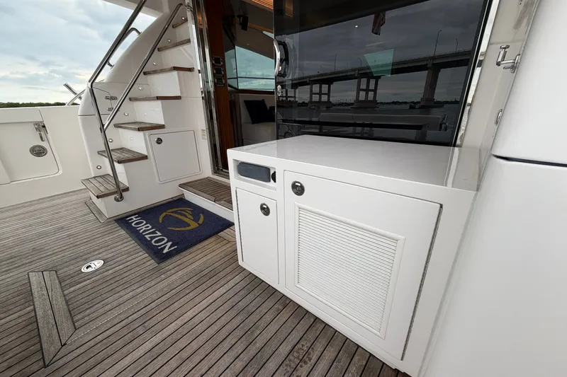 Slide: The Image of Luxury yacht deck with wooden flooring, stairs, and Horizon E56 branding, 2020 model. - 22