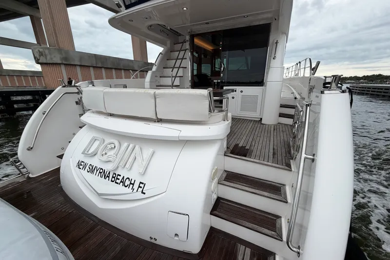 Slide: The Image of Luxury Horizon E56 yacht docked, featuring elegant wooden deck and seating, New Smyrna Beach, FL. - 15