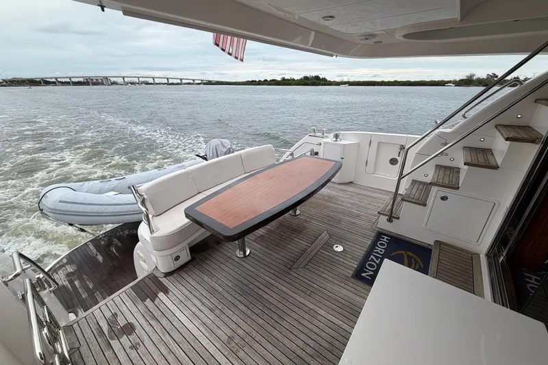 Slide: The Image of Luxury yacht Horizon E56 deck with seating, table, and scenic water view, 2020 model. - 47
