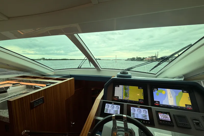 Slide: The Image of Interior view of 2020 Horizon E56 yacht cockpit with navigation screens and scenic water view. - 38