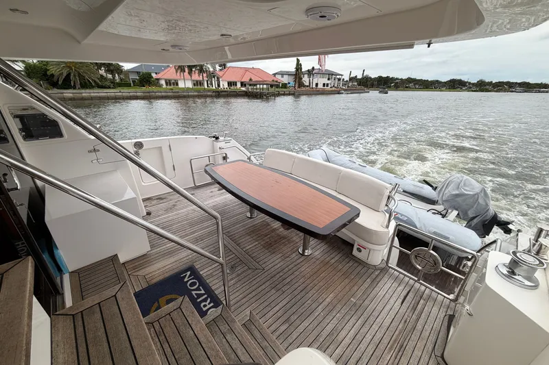 Slide: The Image of Luxury yacht Horizon E56 deck with seating, table, and scenic waterfront view, 2020 model. - 46