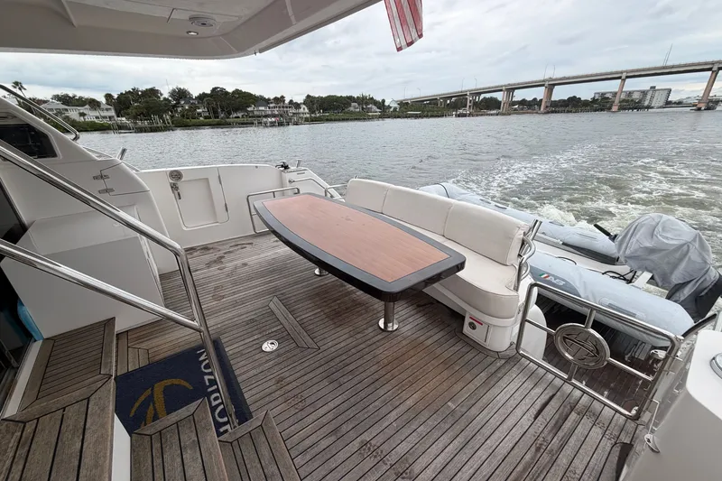 Slide: The Image of Luxury yacht deck with seating and table, Horizon E56, 2020 model, cruising on a scenic waterway. - 24