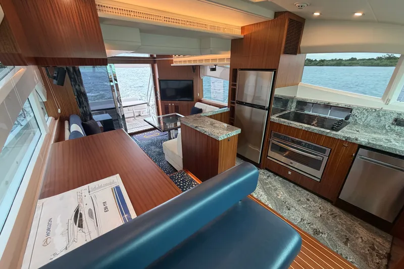 Slide: The Image of Luxurious Horizon E56 yacht interior with modern kitchen, dining area, and scenic water view. - 39