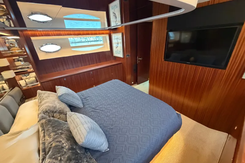 Slide: The Image of Luxurious yacht bedroom with wood paneling, blue bedding, and a wall-mounted TV. Horizon E56, 2020. - 52