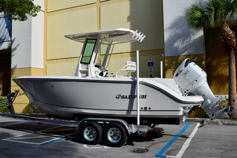 The Image of 2026 Sailfish 232 CC boat on trailer, parked outdoors near a building. - 0
