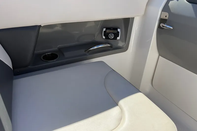 Slide: The Image of Interior of 2016 Chaparral 250 Suncoast boat, featuring seating and control panel. - 21