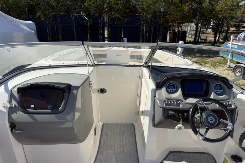 Slide: The Image of 2016 Chaparral 250 Suncoast boat cockpit with steering wheel and dashboard controls. - 14