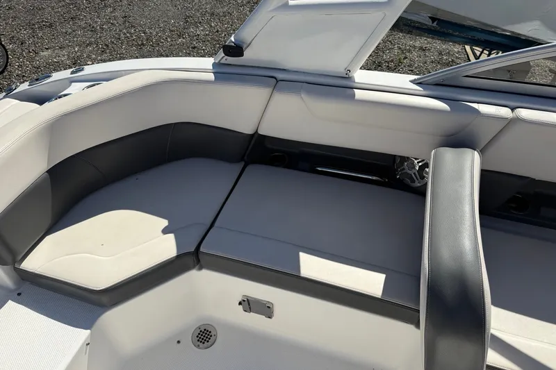 Slide: The Image of 2016 Chaparral 250 Suncoast boat interior with cushioned seating and open storage compartment. - 20