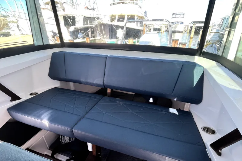 Slide: The Image of Interior seating of 2026 Axopar 29 XC Cross Cabin boat, with marina view. - 25