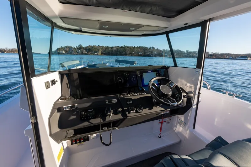 Slide: The Image of Interior view of 2026 Axopar 29 XC Cross Cabin boat, featuring modern dashboard and steering. - 14