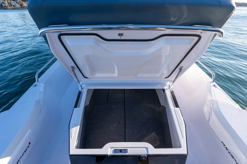 Slide: The Image of Open storage compartment on 2026 Axopar 29 XC Cross Cabin boat, with ocean backdrop. - 21