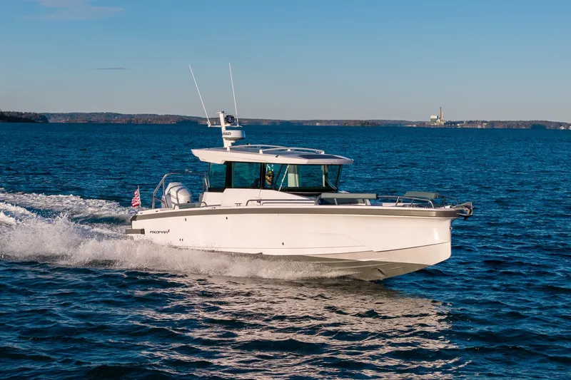 Slide: The Image of 2026 Axopar 29 XC Cross Cabin cruising on open water under clear skies. - 7