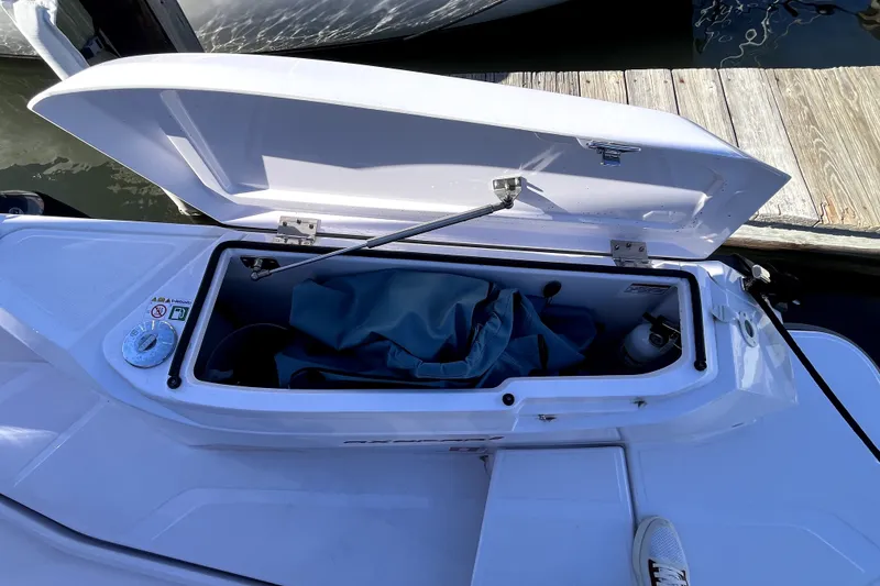 Slide: The Image of Open storage compartment on 2026 Axopar 29 XC Cross Cabin boat, dockside view. - 39
