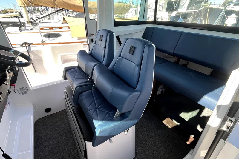 Slide: The Image of 2026 Axopar 29 XC Cross Cabin interior with blue seating and steering wheel. - 27