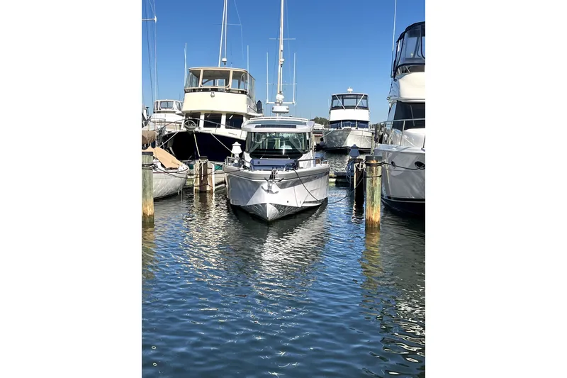 Slide: The Image of 2026 Axopar 29 XC Cross Cabin docked among other boats in a marina. - 8