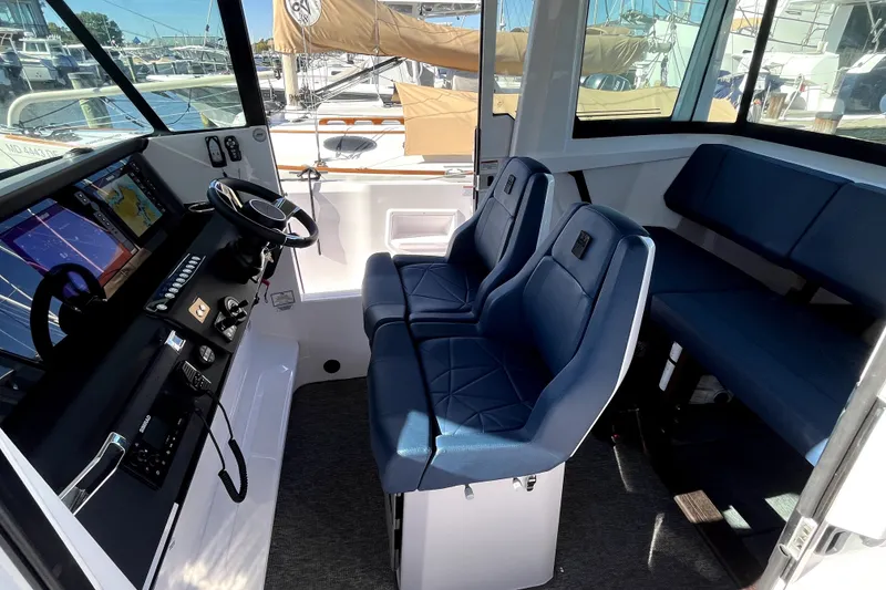 Slide: The Image of 2026 Axopar 29 XC Cross Cabin interior with blue seating and navigation controls. - 28