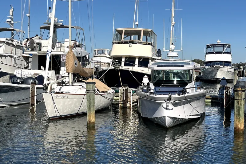 Slide: The Image of 2026 Axopar 29 XC Cross Cabin docked among various boats in a marina. - 5