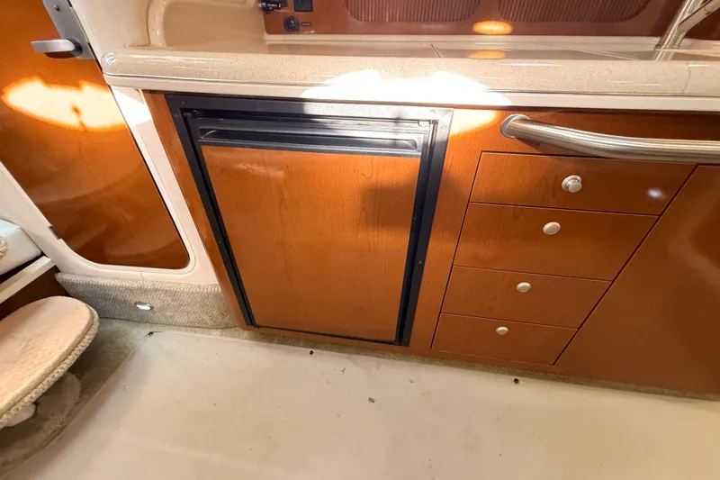 Slide: The Image of Interior of 2008 Sea Ray 340 Sundancer with wooden cabinetry and compact refrigerator. - 30