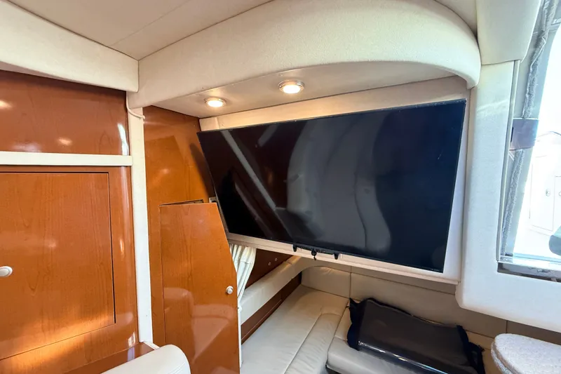 Slide: The Image of Interior of 2008 Sea Ray 340 Sundancer with mounted TV and wooden cabinetry. - 28