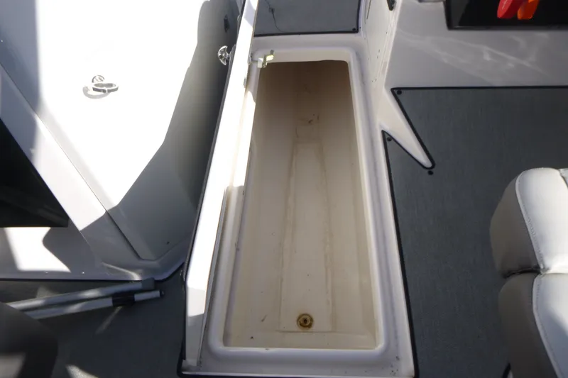 Slide: The Image of 2022 Yamaha Boats AR250 storage compartment with open hatch, showcasing interior space. - 12