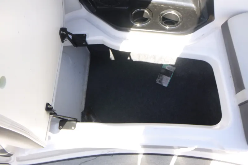 Slide: The Image of Open storage compartment in 2022 Yamaha AR250 boat with cup holders. - 7