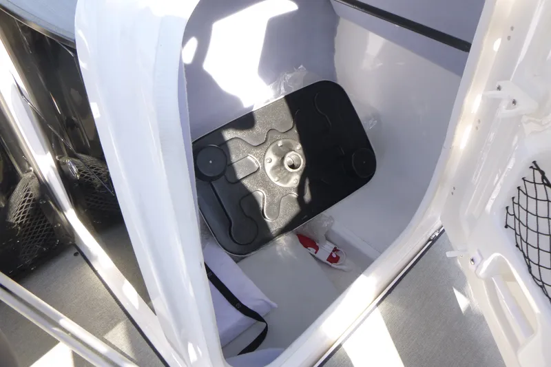 Slide: The Image of 2022 Yamaha Boats AR250 storage compartment with black cover and netted side pocket. - 13