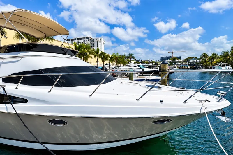 Slide: The Image of 2009 Regal 4080 Sportyacht docked in a sunny marina with palm trees and blue sky. - 2