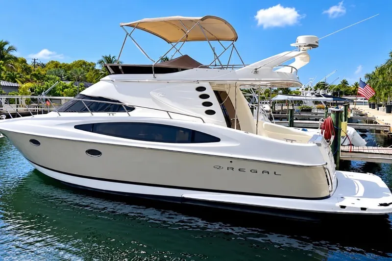 The Image of 2009 Regal 4080 Sportyacht docked in a sunny marina, showcasing sleek design and luxury. - 0
