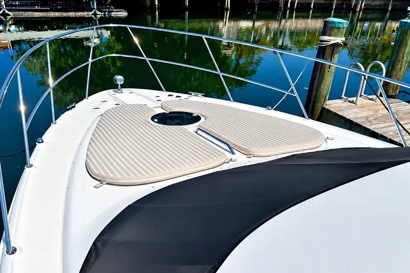 Slide: The Image of 2009 Regal 4080 Sportyacht bow view with sun pads and railing at dock. - 1