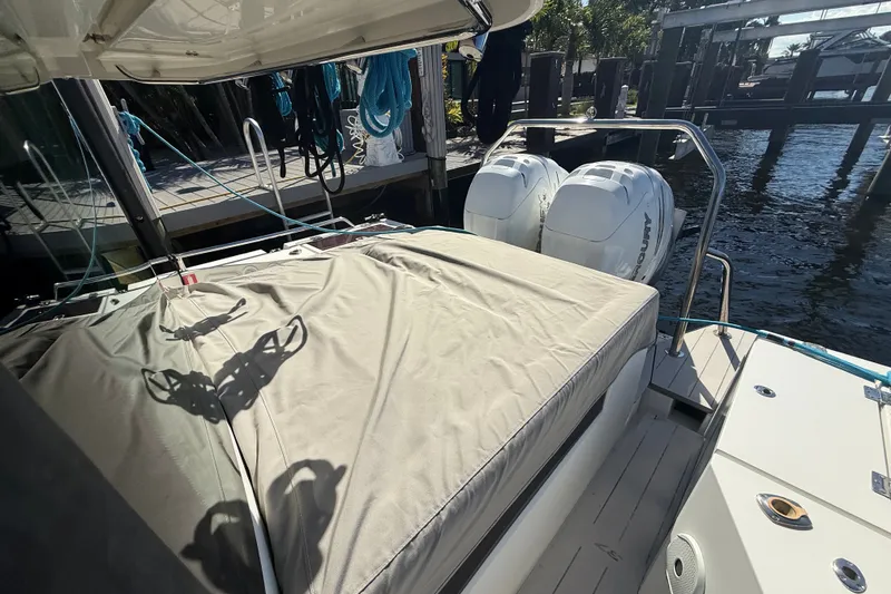 Slide: The Image of 2018 Axopar 37 Sports Cabin with twin Mercury outboard engines docked by the water. - 35