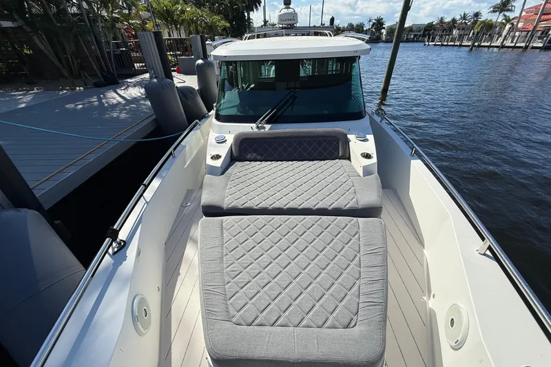Slide: The Image of 2018 Axopar 37 Sports Cabin with cushioned deck, docked by the water. - 31